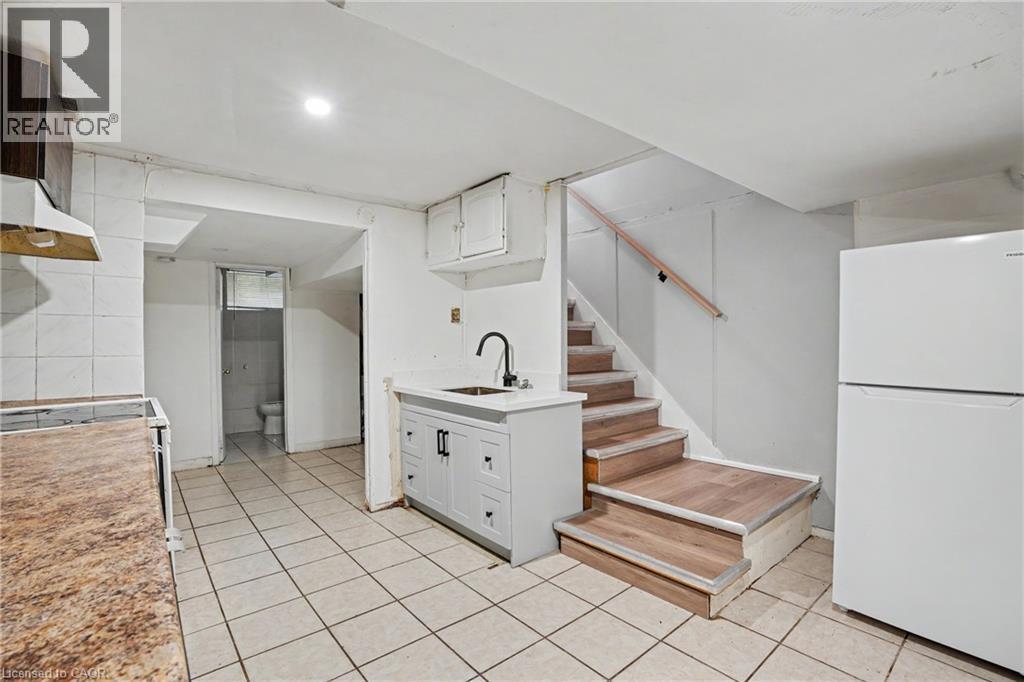Tiled flooring spanning the visible area, with a white two-door refrigerator - 47 Bowman Street, Hamilton, ON - Indoor Photo Showing Kitchen