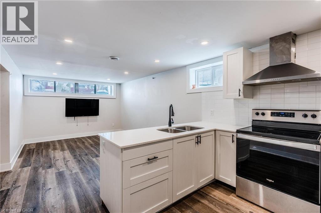 Contemporary kitchen with white shaker cabinetry, stainless steel appliances, quartz countertops, and a subway tile backsplash - 16 Ronaldshay Avenue, Hamilton, ON - Indoor Photo Showing Kitchen With Double Sink