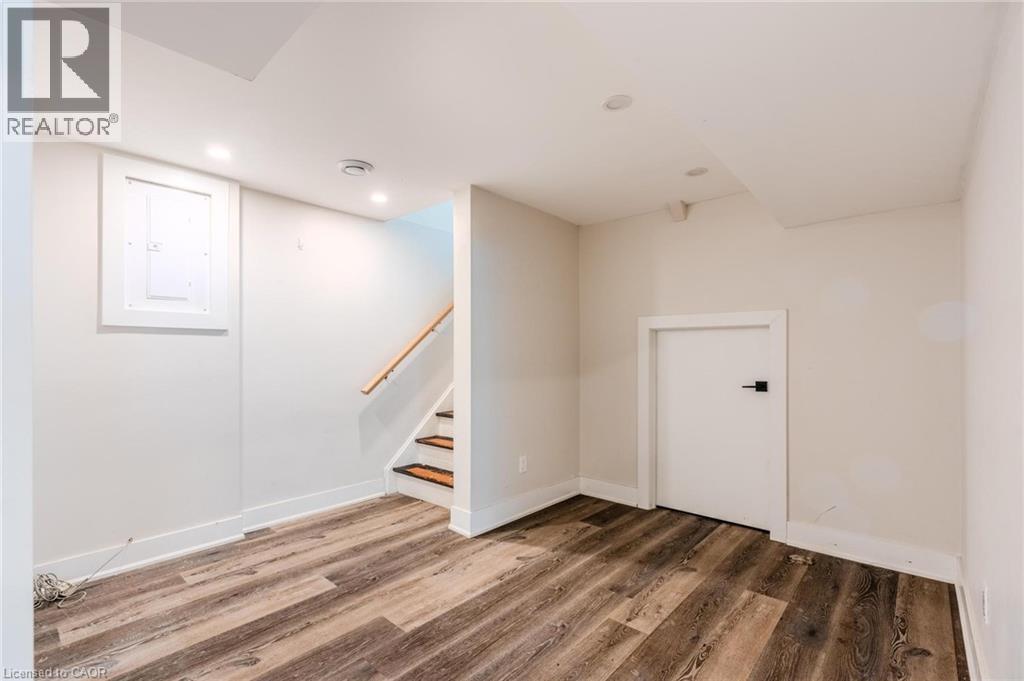 Finished lower level with wood-finish flooring, recessed lighting, and white baseboards - 16 Ronaldshay Avenue, Hamilton, ON - Indoor Photo Showing Other Room