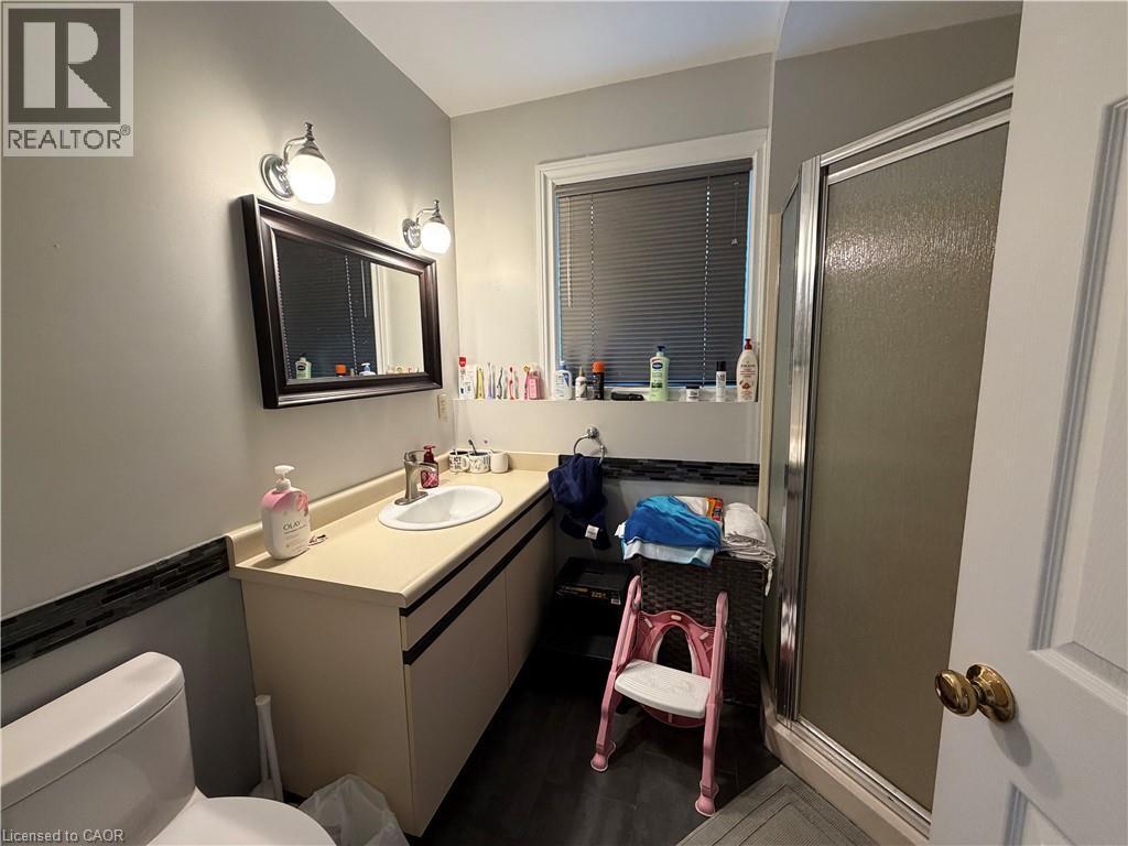 Bathroom featuring a single vanity with an integrated sink, framed mirror, and a glass-enclosed shower - 436 Gatestone Boulevard, Waterloo, ON - Indoor Photo Showing Bathroom