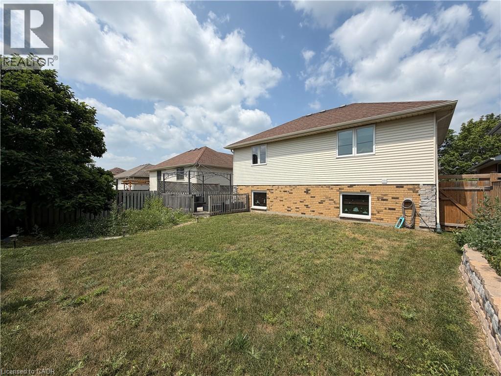 Rear exterior featuring light-toned siding, a brick lower level, and a multi-level deck - 436 Gatestone Boulevard, Waterloo, ON - Outdoor