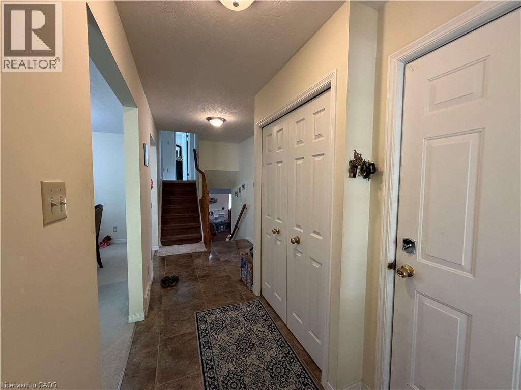 Entryway featuring tile flooring, a staircase with wood treads, and white bi-fold closet doors - 436 Gatestone Boulevard, Waterloo, ON - Indoor Photo Showing Other Room