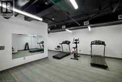 Fitness area featuring wall-mounted mirrors and patterned carpet flooring -