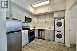 Kitchen featuring light wood-finish cabinetry, stainless steel appliances, white countertops, and wood-finish flooring -