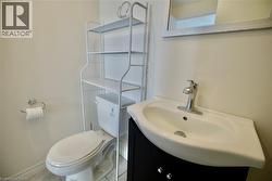 White porcelain sink with chrome faucet, set into a dark wood-finish vanity with chrome hardware -