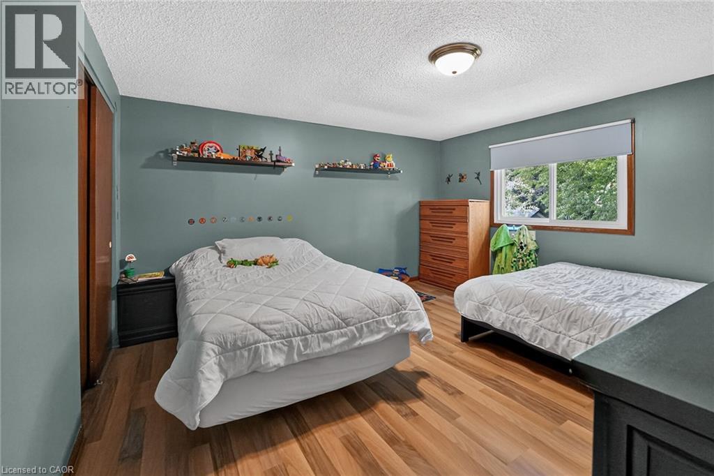 Bedroom featuring wood-finish flooring, a double-pane window, and a flush-mount ceiling light fixture - 3 Orchard Parkway, Grimsby, ON - Indoor Photo Showing Bedroom