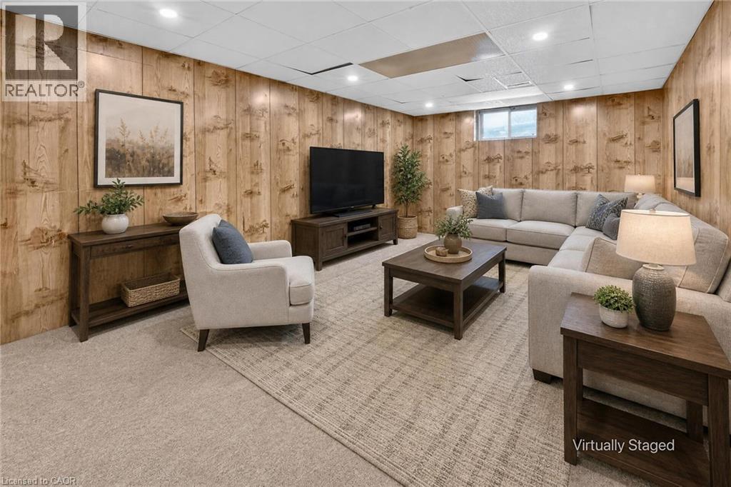 Recessed lighting illuminates the room, featuring wood-panel walls and light-toned carpeting throughout - 3 Orchard Parkway, Grimsby, ON - Indoor Photo Showing Basement