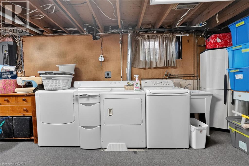 Utility area featuring a top-load washer, a front-load dryer, and a utility sink - 3 Orchard Parkway, Grimsby, ON - Indoor Photo Showing Laundry Room