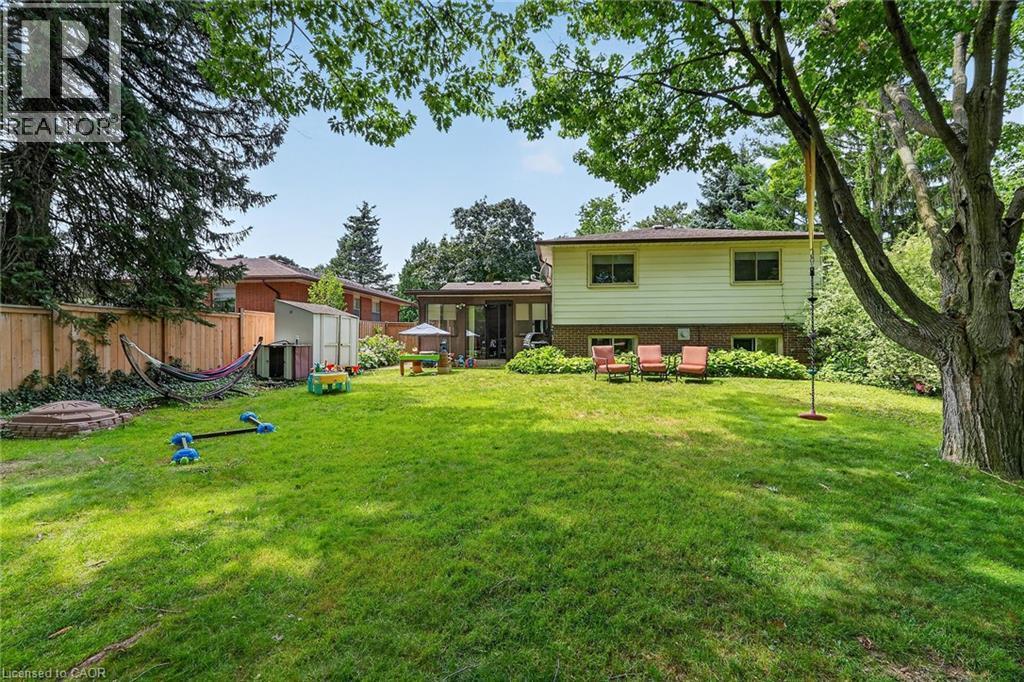 Expansive rear yard featuring a wide lawn, mature trees, and a wooden privacy fence - 3 Orchard Parkway, Grimsby, ON - Outdoor