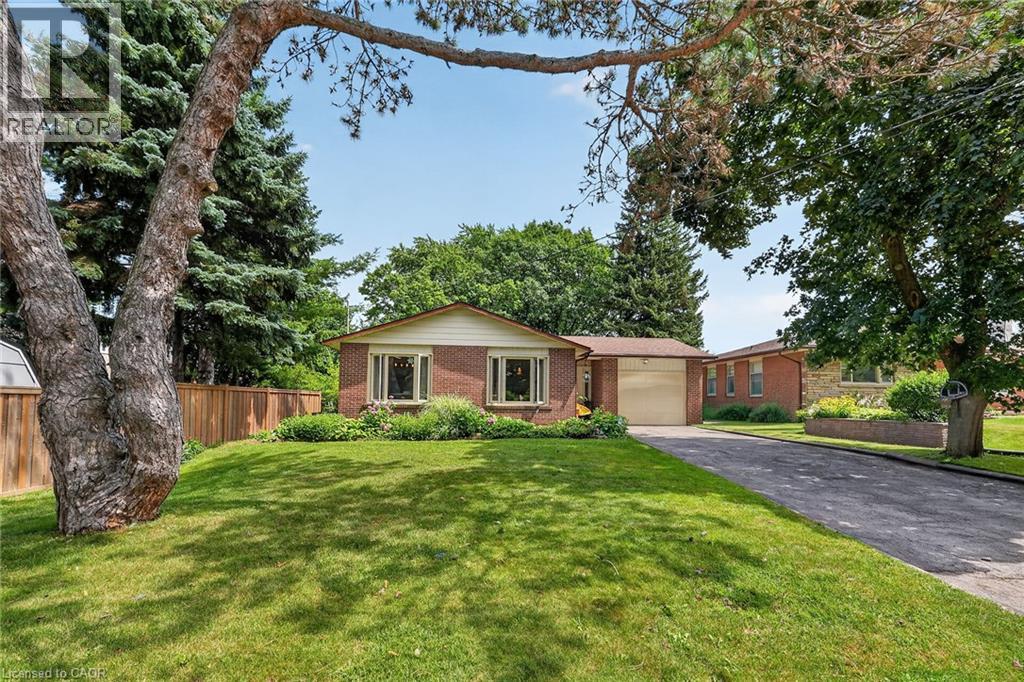 Brick exterior with a detached garage, established front yard, mature trees, and a paved driveway - 3 Orchard Parkway, Grimsby, ON - Outdoor