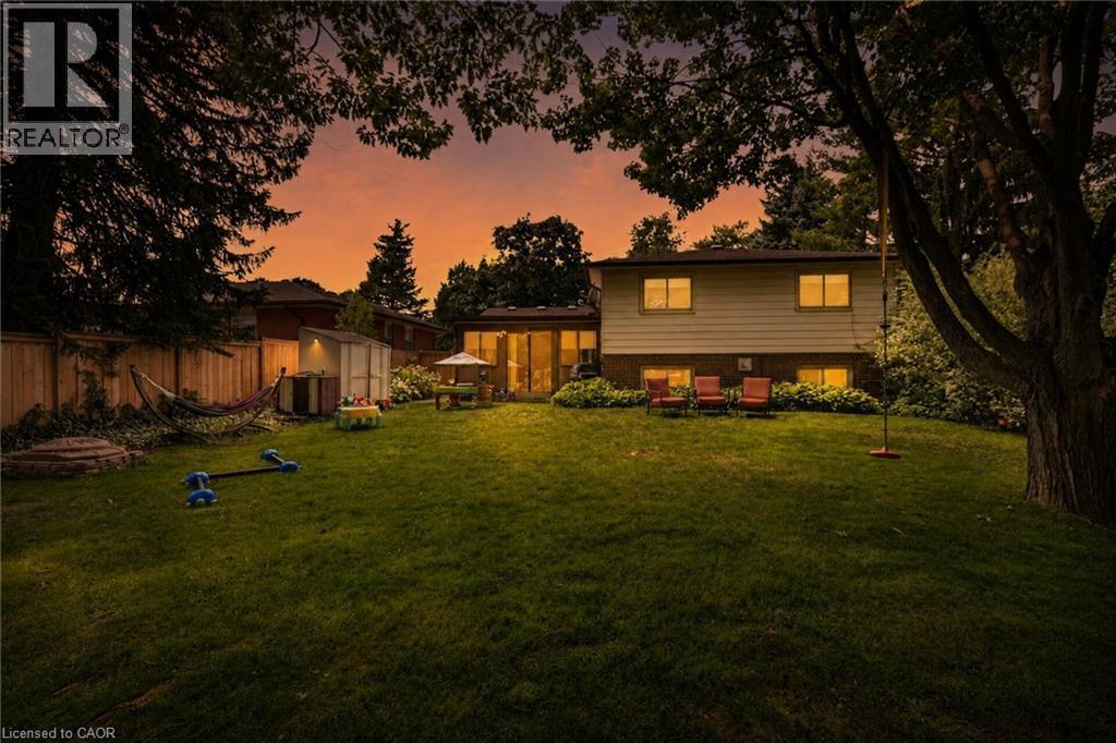 Expansive green lawn with mature trees and privacy fencing - 3 Orchard Parkway, Grimsby, ON - Outdoor With Backyard