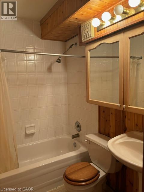 Bathroom featuring a tiled shower/tub combination, wood plank ceiling details, and a wall-mounted vanity with a light fixture - 30 Summit Avenue Unit# 604, Hamilton, ON - Indoor Photo Showing Bathroom