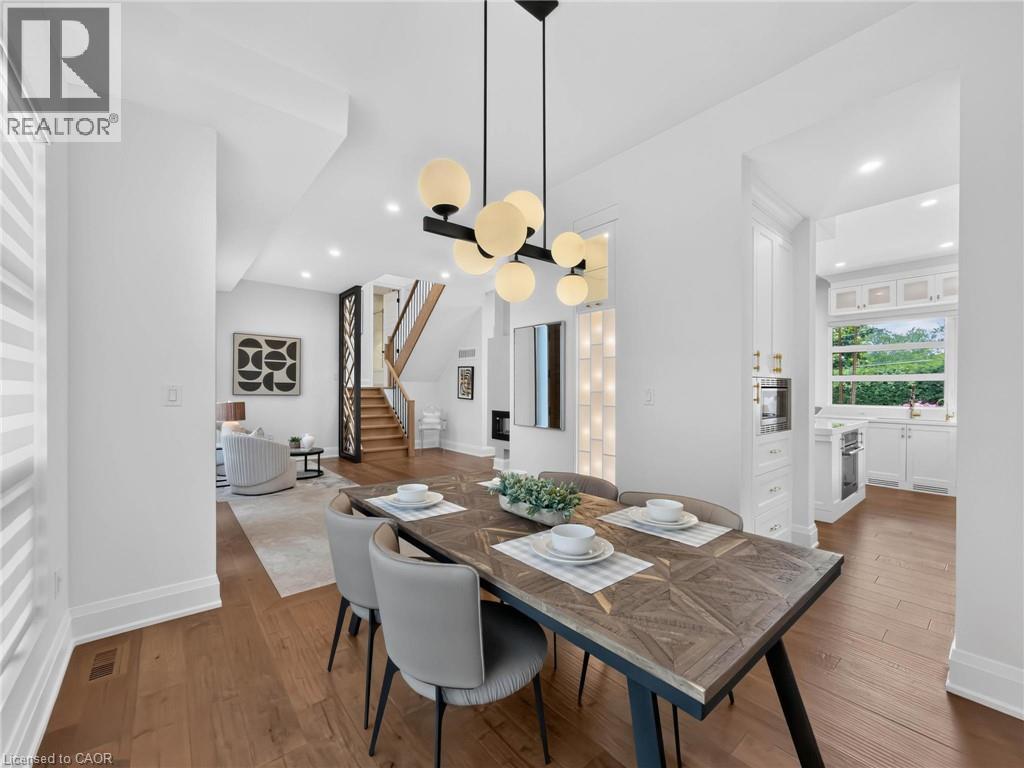 Dining area featuring a contemporary chandelier, hardwood flooring, and neutral wall tones - 5178 Hunter Drive, Burlington, ON - Indoor Photo Showing Dining Room