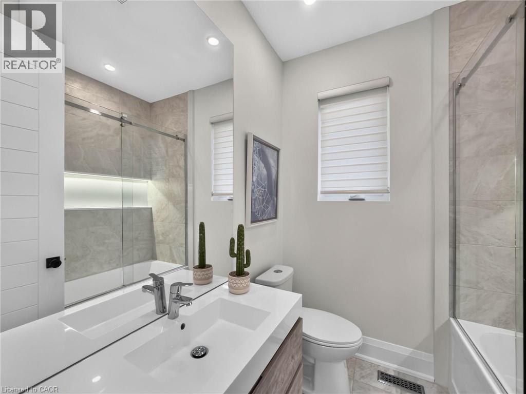 Bathroom featuring a vanity with an integrated sink, chrome fixtures, and a large mirror - 5178 Hunter Drive, Burlington, ON - Indoor Photo Showing Bathroom