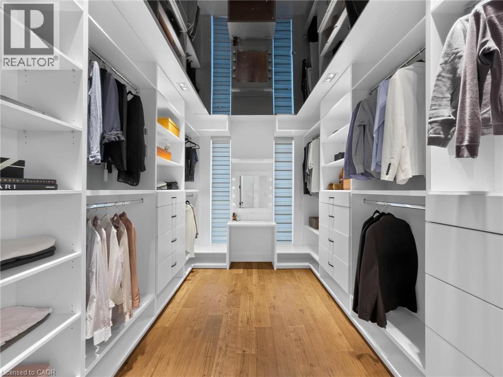 Custom built-in closet system featuring extensive shelving, hanging rods, and integrated drawers - 5178 Hunter Drive, Burlington, ON - Indoor With Storage