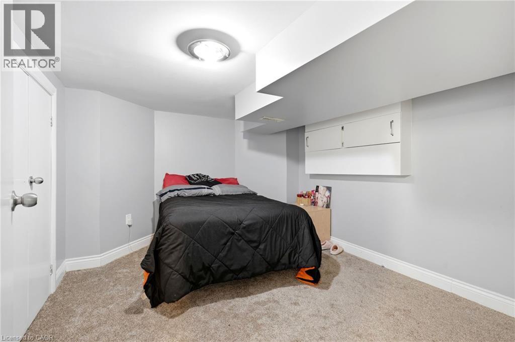 Carpeted room featuring light gray walls, white baseboards, and a flush-mount ceiling light fixture - 127 Taylor Avenue, Hamilton, ON - Indoor Photo Showing Bedroom