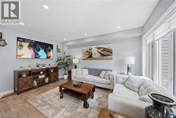 Living space with wood-finish flooring, recessed lighting, and light gray wall paint - 