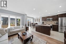 Open-concept living space with a kitchen island, wood-finish flooring, and recessed lighting - 