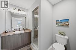 Bathroom featuring a vanity with a countertop, integrated sink, and wood-finish cabinetry - 