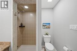 Full bathroom featuring a walk-in shower with tiled walls and a recessed light - 
