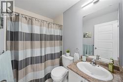Bathroom featuring a vanity with a white oval undermount sink, a chrome faucet, and a patterned countertop - 