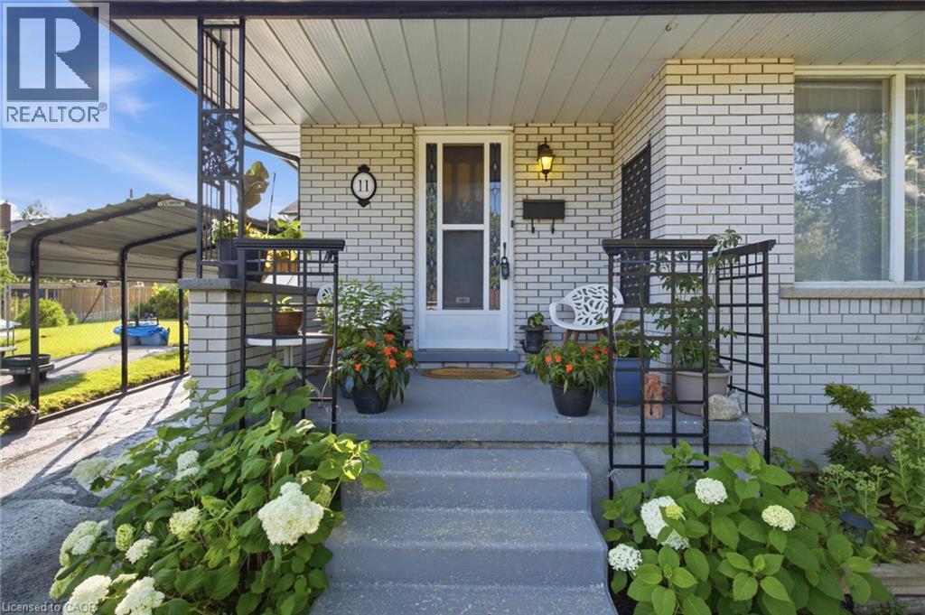 Front exterior featuring light-colored brick siding and a covered entry - 11 Summit Crescent, Guelph, ON - Outdoor With Deck Patio Veranda