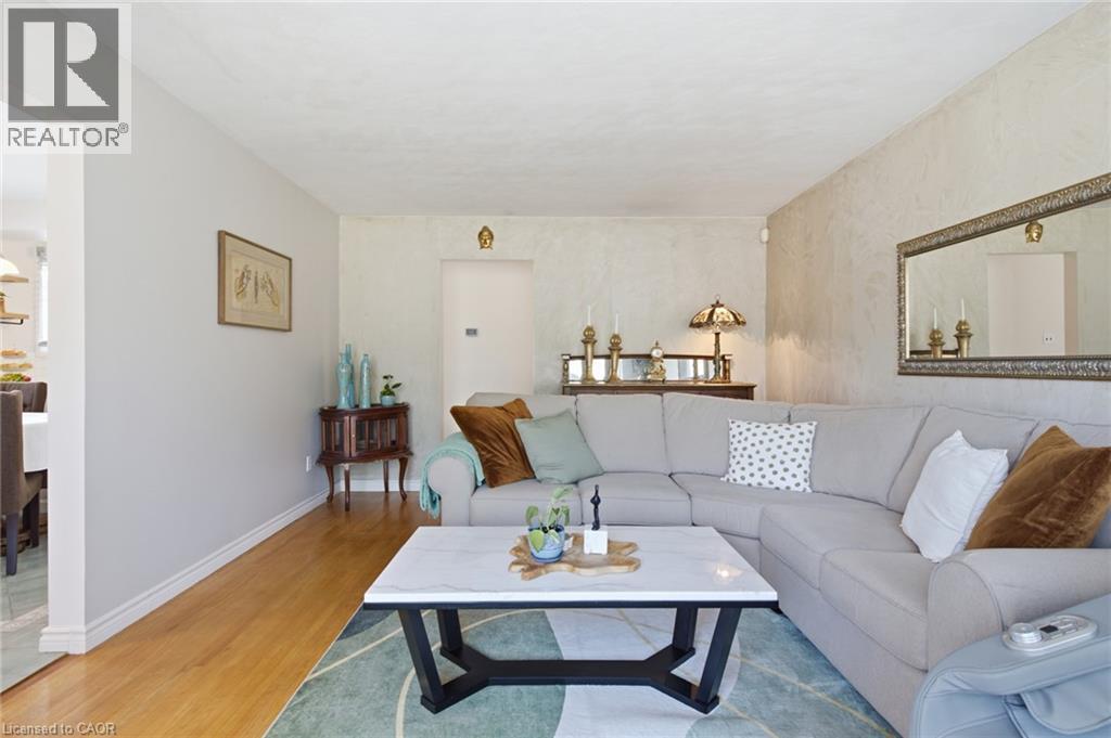 Bright living space featuring wood-finish flooring, textured wall finishes, and a spacious sectional sofa - 11 Summit Crescent, Guelph, ON - Indoor Photo Showing Living Room