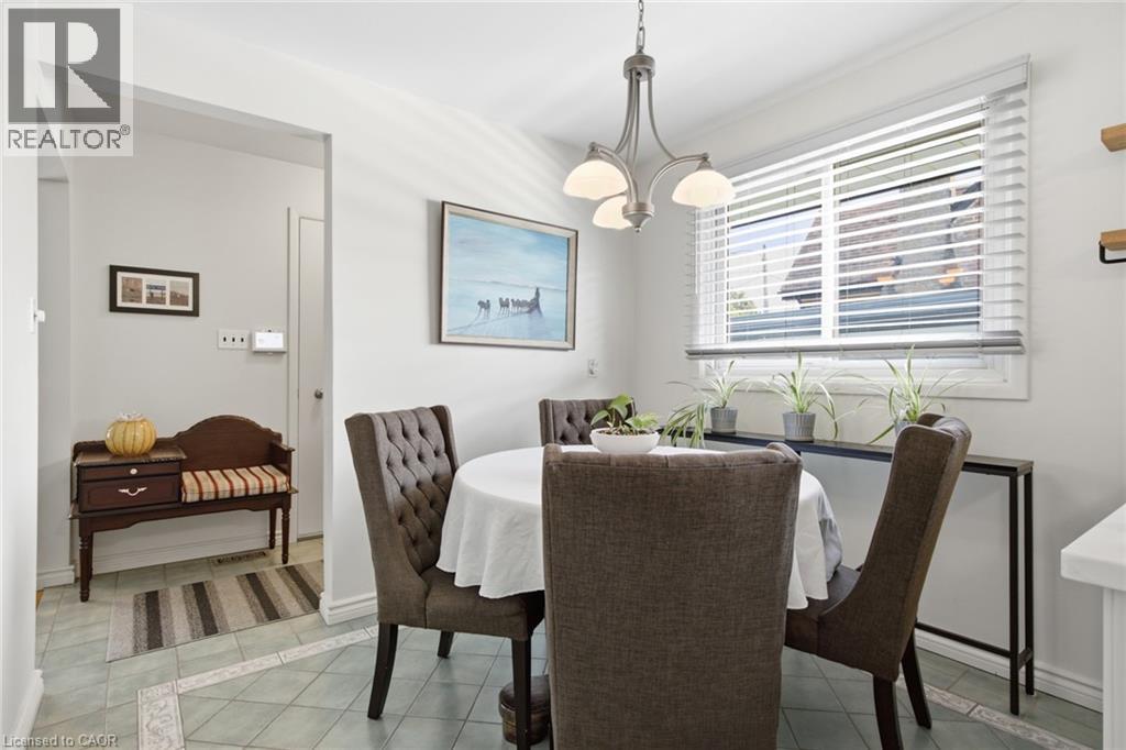 Dining area featuring a four-light chandelier, a large window with blinds, and decorative tile flooring - 11 Summit Crescent, Guelph, ON - Indoor Photo Showing Dining Room