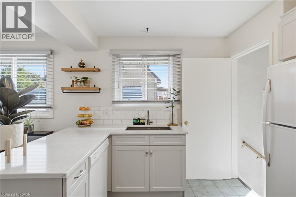 Kitchen featuring light gray cabinetry, white countertops, subway tile backsplash, and a stainless steel sink with a gooseneck faucet - 11 Summit Crescent, Guelph, ON - Indoor Photo Showing Kitchen