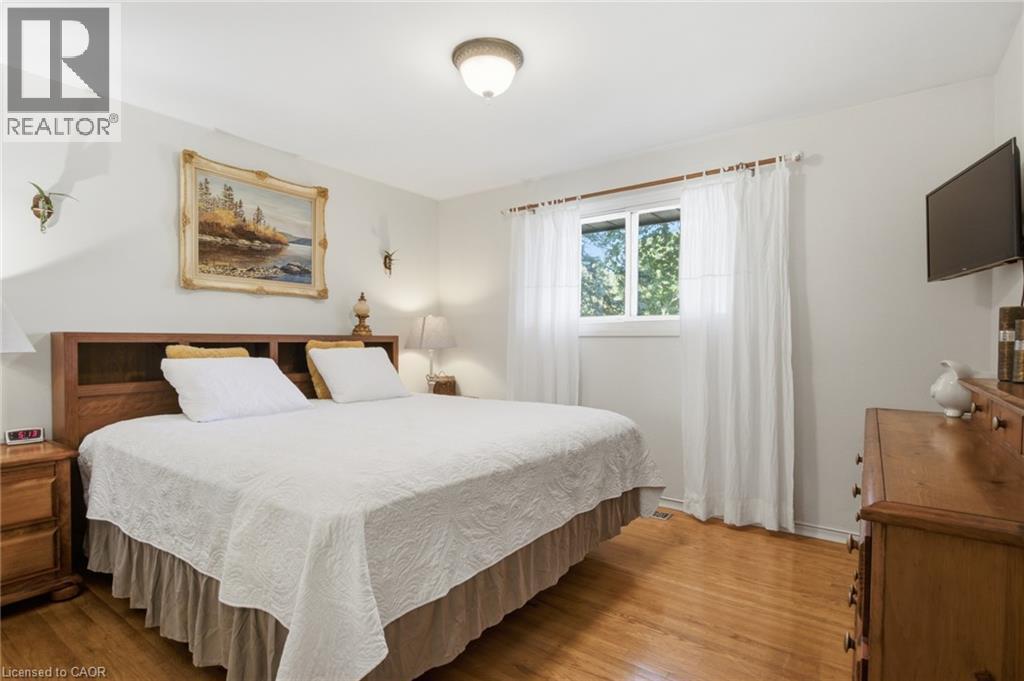 Bedroom featuring wood-finish flooring, a double window with white curtains, white walls, and a ceiling-mounted light fixture - 11 Summit Crescent, Guelph, ON - Indoor Photo Showing Bedroom