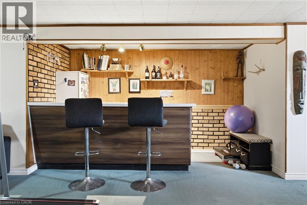 Built-in bar featuring a wood-finish countertop, wood-look paneling, and brick-patterned wainscoting - 11 Summit Crescent, Guelph, ON - Indoor Photo Showing Other Room