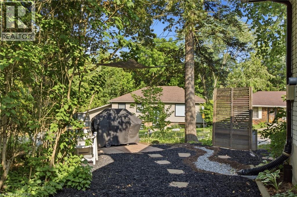 Landscaped outdoor area featuring dark ground cover, stepping stones, and a decorative gravel path - 11 Summit Crescent, Guelph, ON - Outdoor
