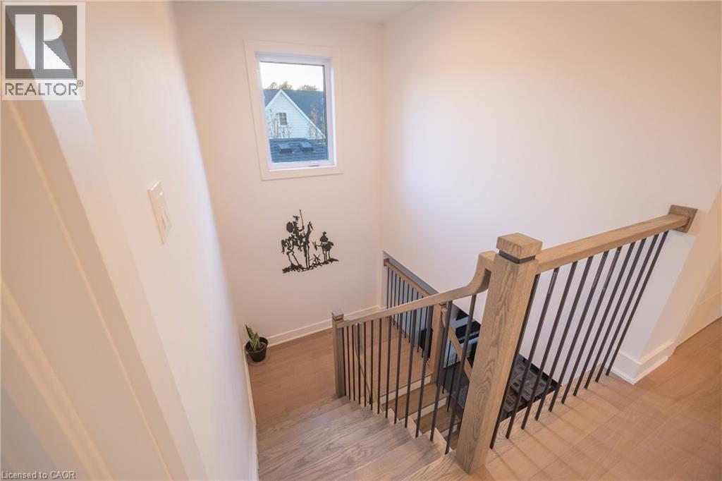 Staircase featuring wood-finish treads and risers, a light wood-finish handrail, and black metal balusters - 9 Princeton Common, St. Catharines, ON - Indoor Photo Showing Other Room