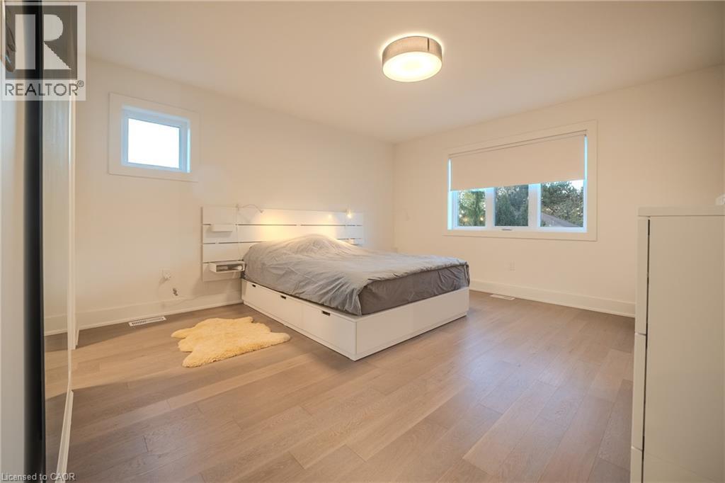 Bright interior space featuring light wood-finish flooring, white walls, and a contemporary flush-mount ceiling light - 9 Princeton Common, St. Catharines, ON - Indoor Photo Showing Bedroom
