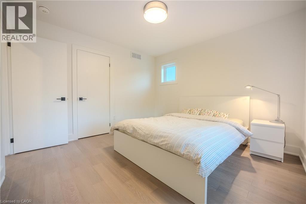 Light wood-finish flooring complements clean white walls - 9 Princeton Common, St. Catharines, ON - Indoor Photo Showing Bedroom