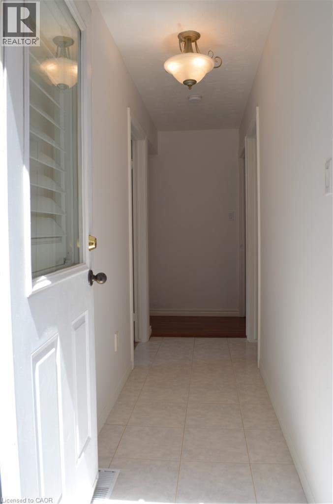 Entryway featuring white panel door with glass insert, overhead semi-flush mount light fixture, and ceramic tile flooring - 275 Locheed Drive Unit# Lower, Hamilton, ON - Indoor Photo Showing Other Room