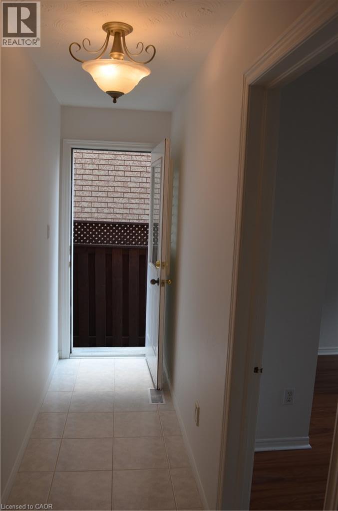 Foyer with tiled flooring, traditional semi-flush mount lighting fixture, and a white door with transom window - 275 Locheed Drive Unit# Lower, Hamilton, ON - Indoor Photo Showing Other Room