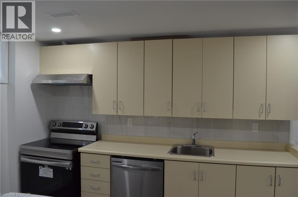 Kitchen area featuring light-toned cabinetry, a stainless steel range hood, a stainless steel electric range, a stainless steel dishwasher, and a double basin stainless steel sink - 275 Locheed Drive Unit# Lower, Hamilton, ON - Indoor Photo Showing Kitchen