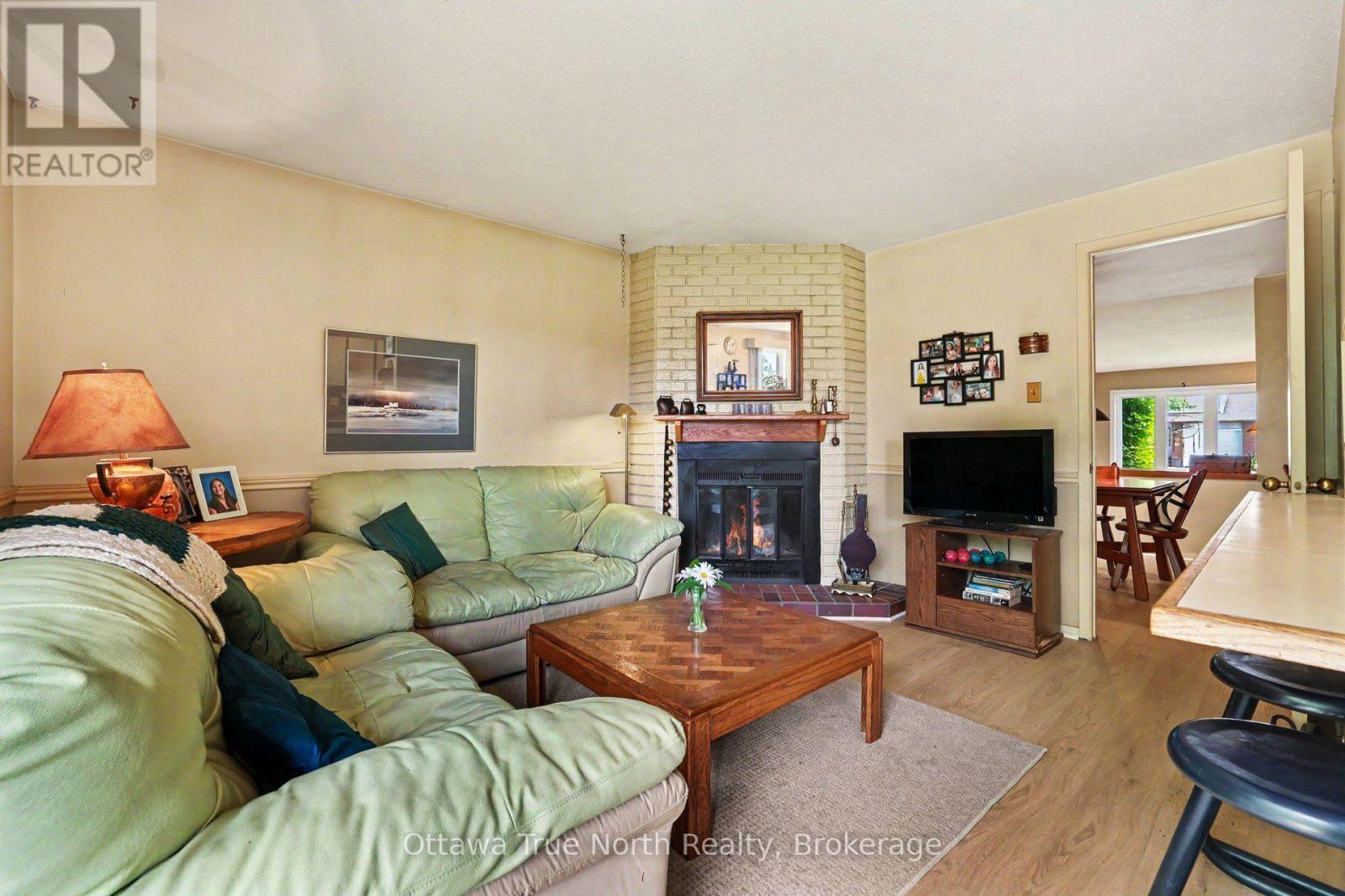 Family room with wood fireplace - 41 Aldgate Crescent, Ottawa, ON - Indoor Photo Showing Living Room With Fireplace