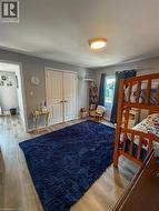 second level. Spacious bedroom with wood-finish flooring and a flush-mount ceiling light - 