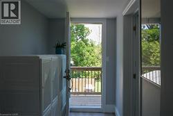 Outdoor deck featuring natural wood railing with black metal spindles and a lush green tree canopy - 