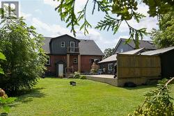 Expansive green lawn with a sizable wood deck featuring a privacy fence - 