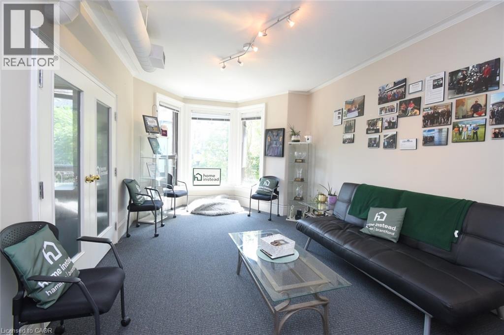 Room featuring a bay window, track lighting, and exposed ceiling ductwork - 108 George Street, Hamilton, ON