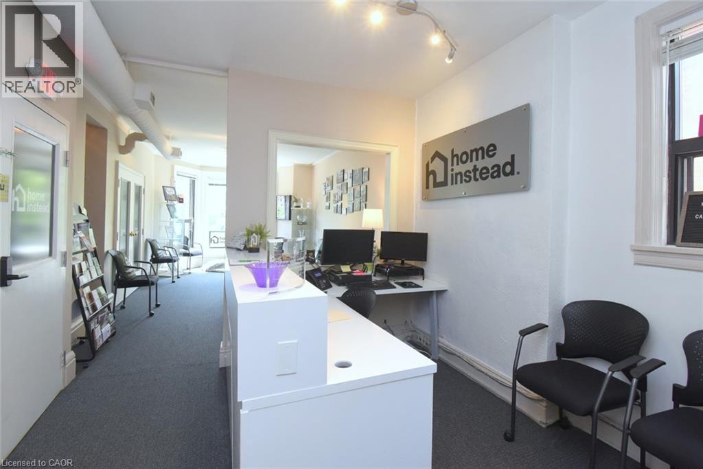 Reception area featuring a white desk, track lighting, and dark gray carpet - 108 George Street, Hamilton, ON