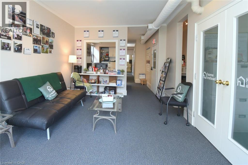 Open-concept reception area with durable gray carpeting and neutral wall tones - 108 George Street, Hamilton, ON