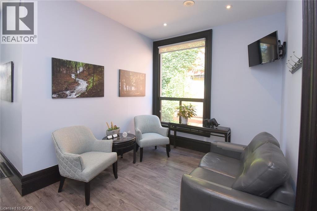 Light wood-finish flooring with dark baseboards - 108 George Street, Hamilton, ON