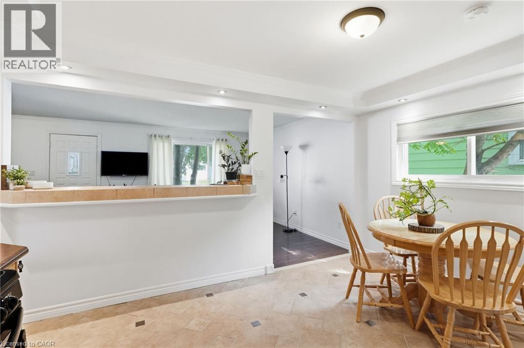 Dining area featuring light-toned square tile flooring with dark accent squares, a rectangular window with roller blinds, and a semi-flush mount ceiling light fixture - 432 Upper Sherman Avenue, Hamilton, ON - Indoor Photo Showing Dining Room