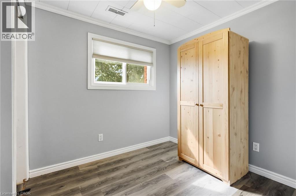Room featuring light gray walls, wood-finish flooring, and a white ceiling with a flush-mount light and ceiling fan - 432 Upper Sherman Avenue, Hamilton, ON - Indoor Photo Showing Other Room
