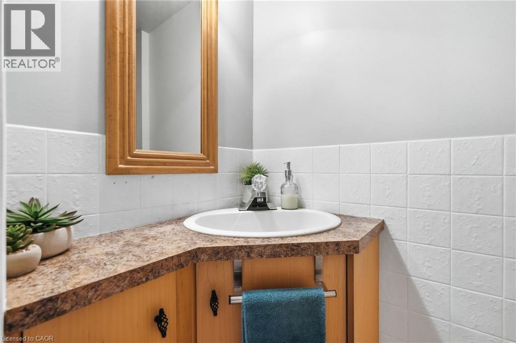 Corner vanity with a built-in sink, wood-finish cabinetry, and decorative hardware - 432 Upper Sherman Avenue, Hamilton, ON - Indoor Photo Showing Bathroom