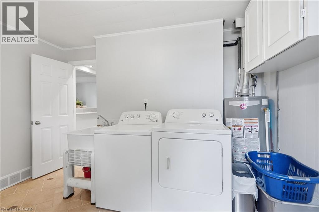 Dedicated laundry area featuring a utility sink, upper cabinetry, and tiled flooring - 432 Upper Sherman Avenue, Hamilton, ON - Indoor Photo Showing Laundry Room